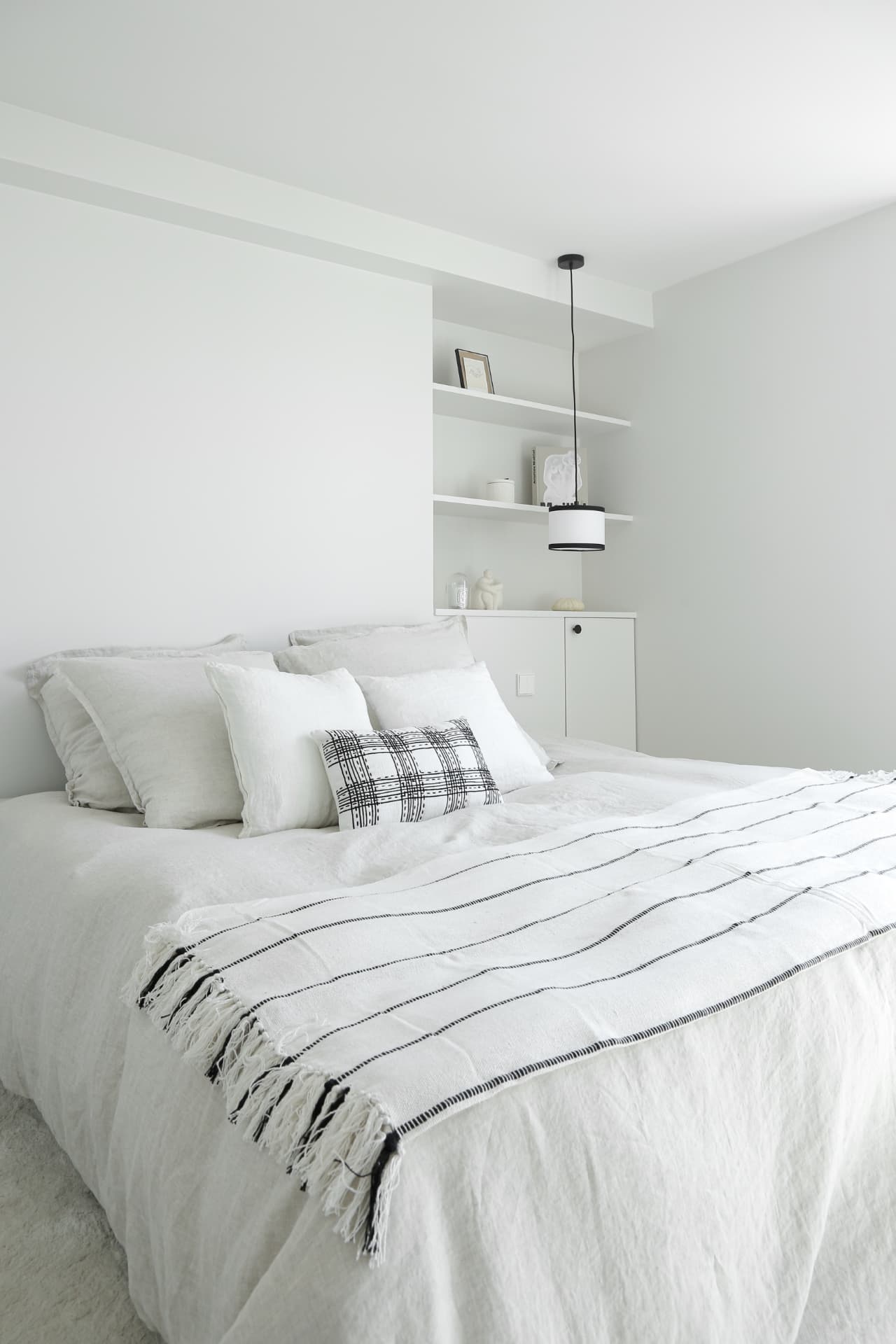 Chambre blanche avec étagères intégrées