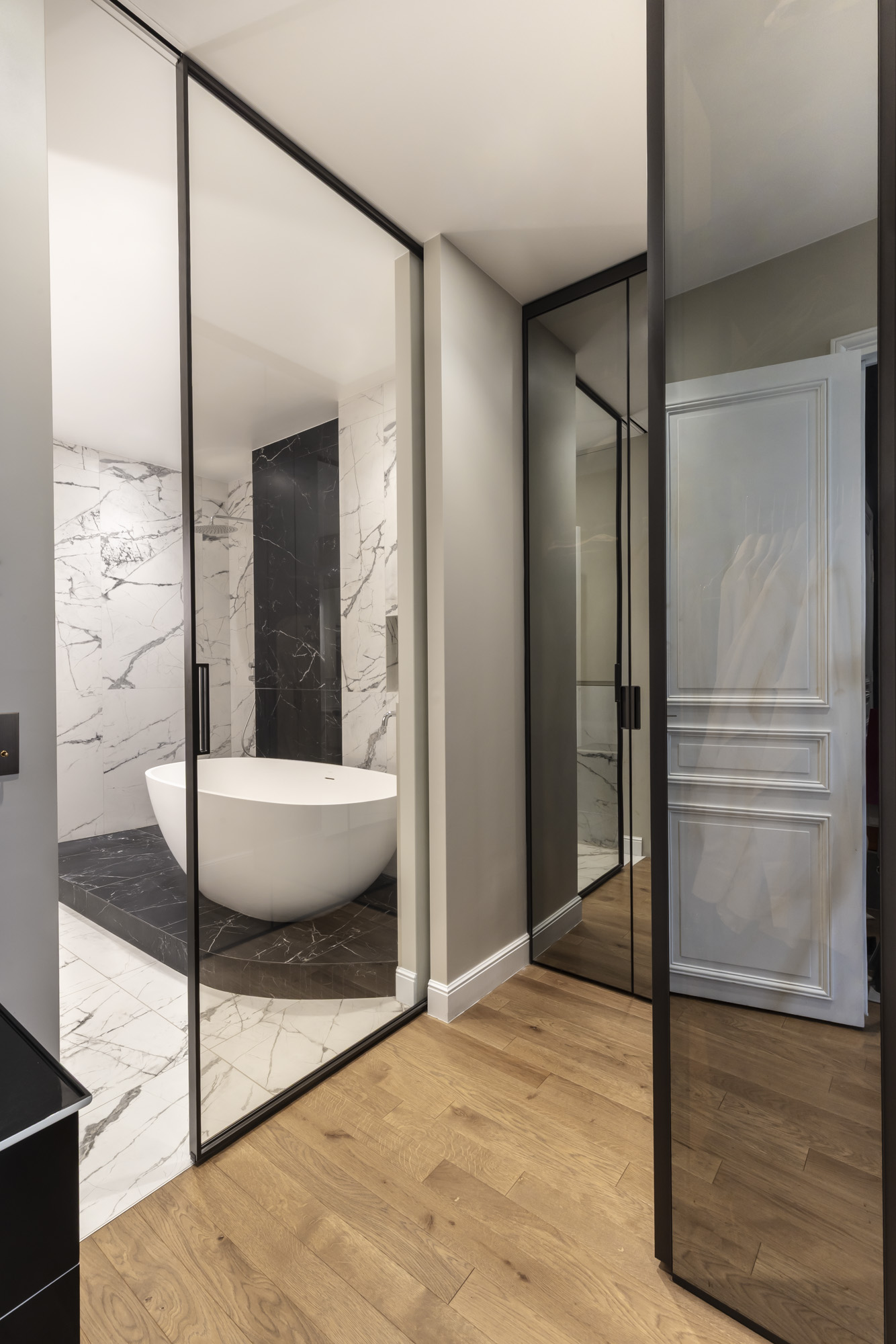 Salle de bain vue depuis le dressing, portes miroir à cadre noir