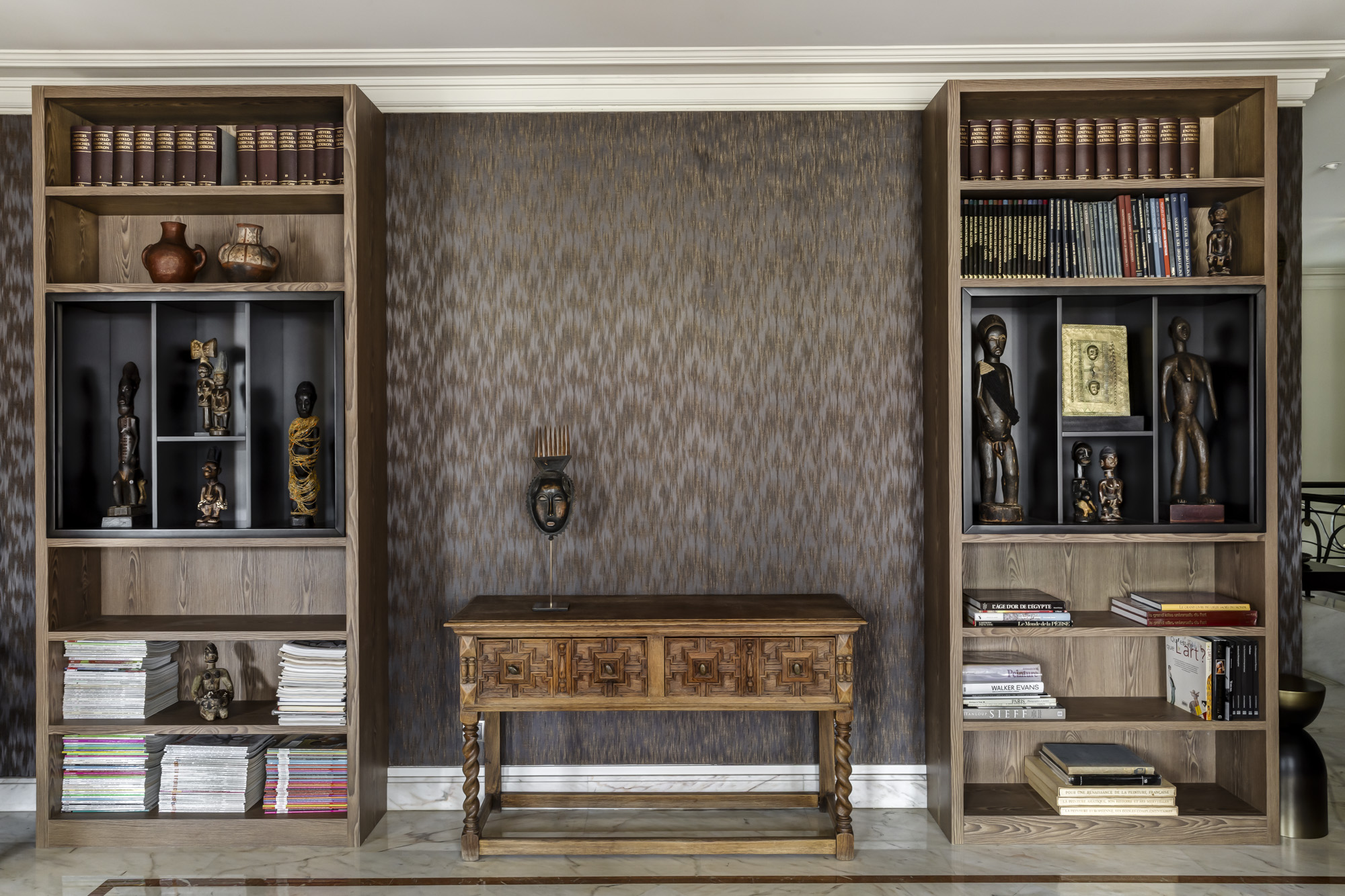 Bibliothèque double hauteur, objets d'art et console ancienne