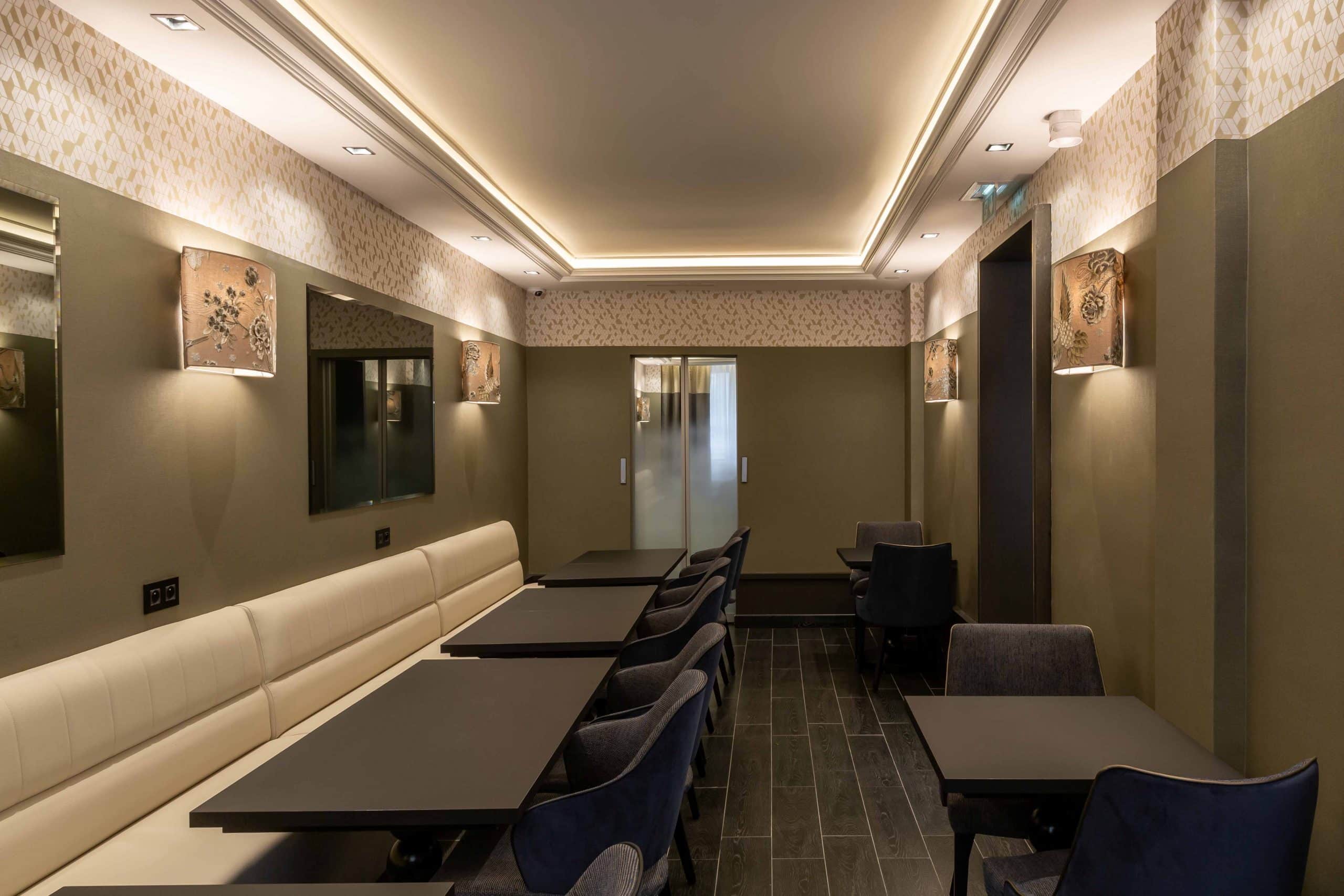 Banquette et tables de la salle commune de l'Hôtel Daunou Opéra
