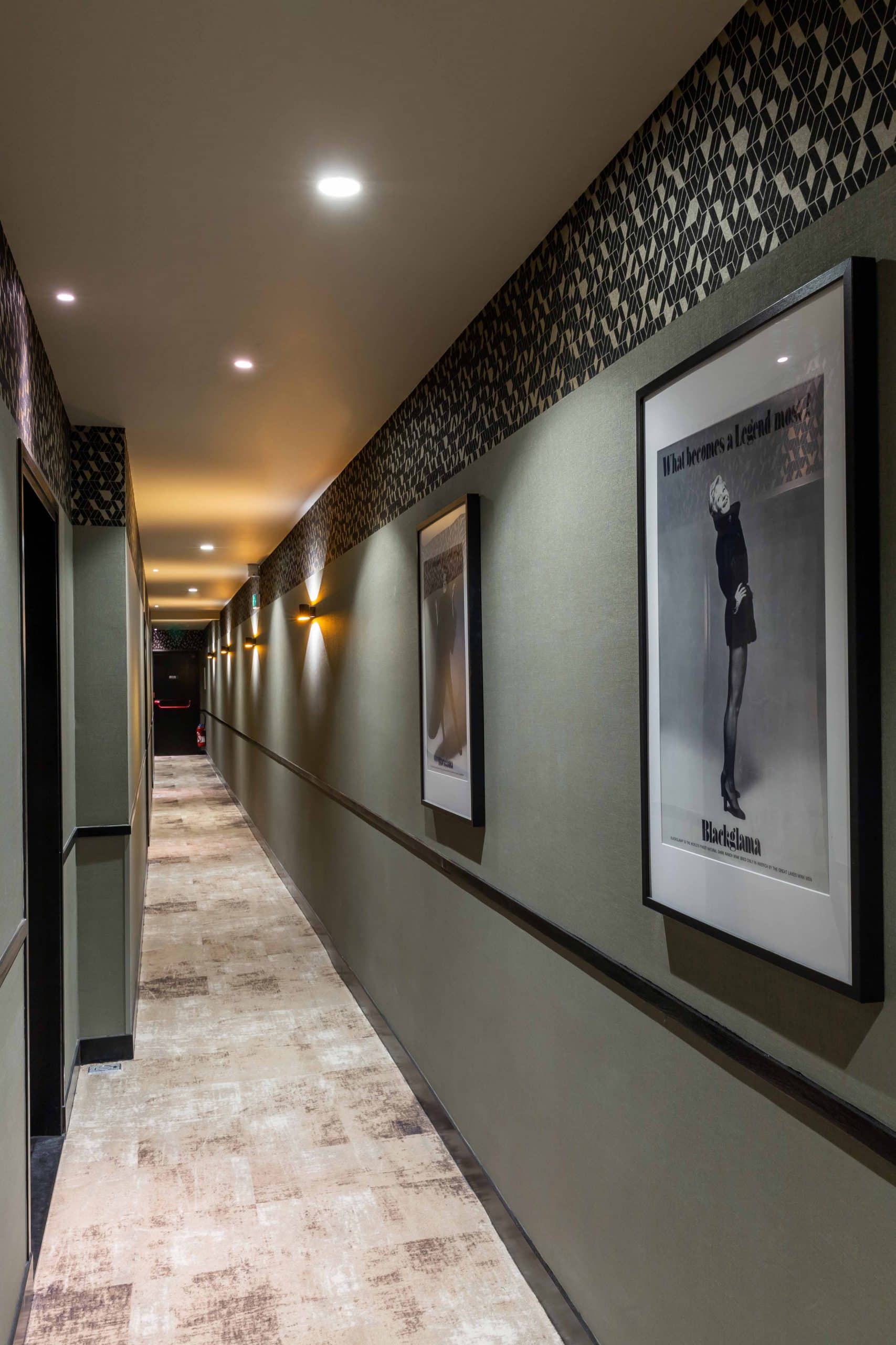 Couloir de distribution des chambres de l'Hôtel Daunou Opéra, cadres alignés au mur
