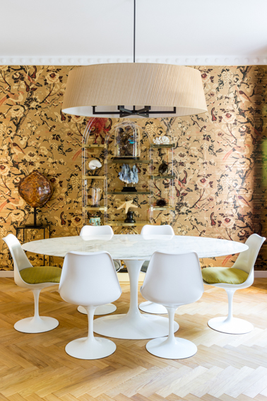 Salle à manger du duplex La Rochefoucauld, table ovale en marbre, chaises Tulip et papier peint végétal
