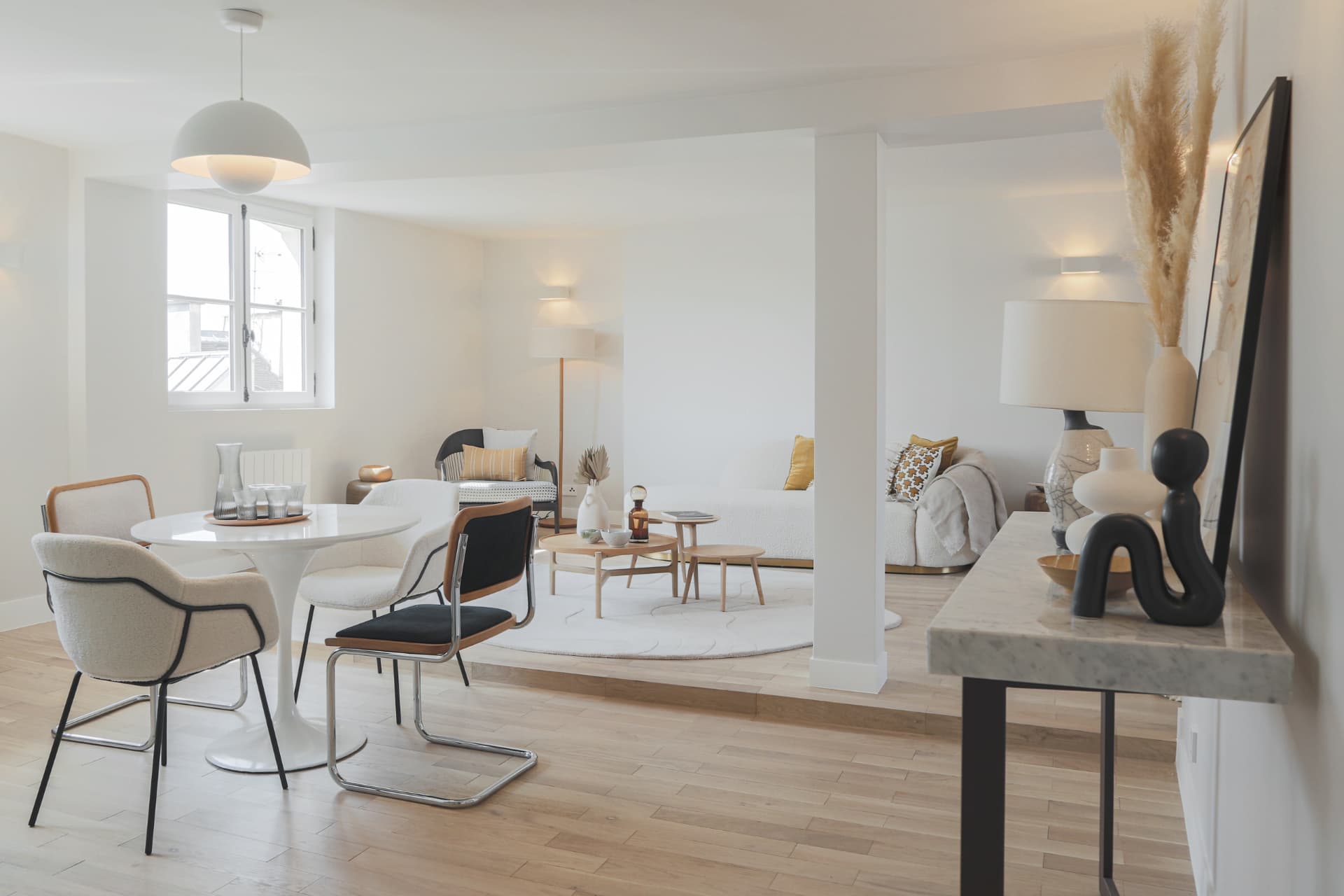 Séjour et salle à manger d'un appartement, table ronde et mobilier clair