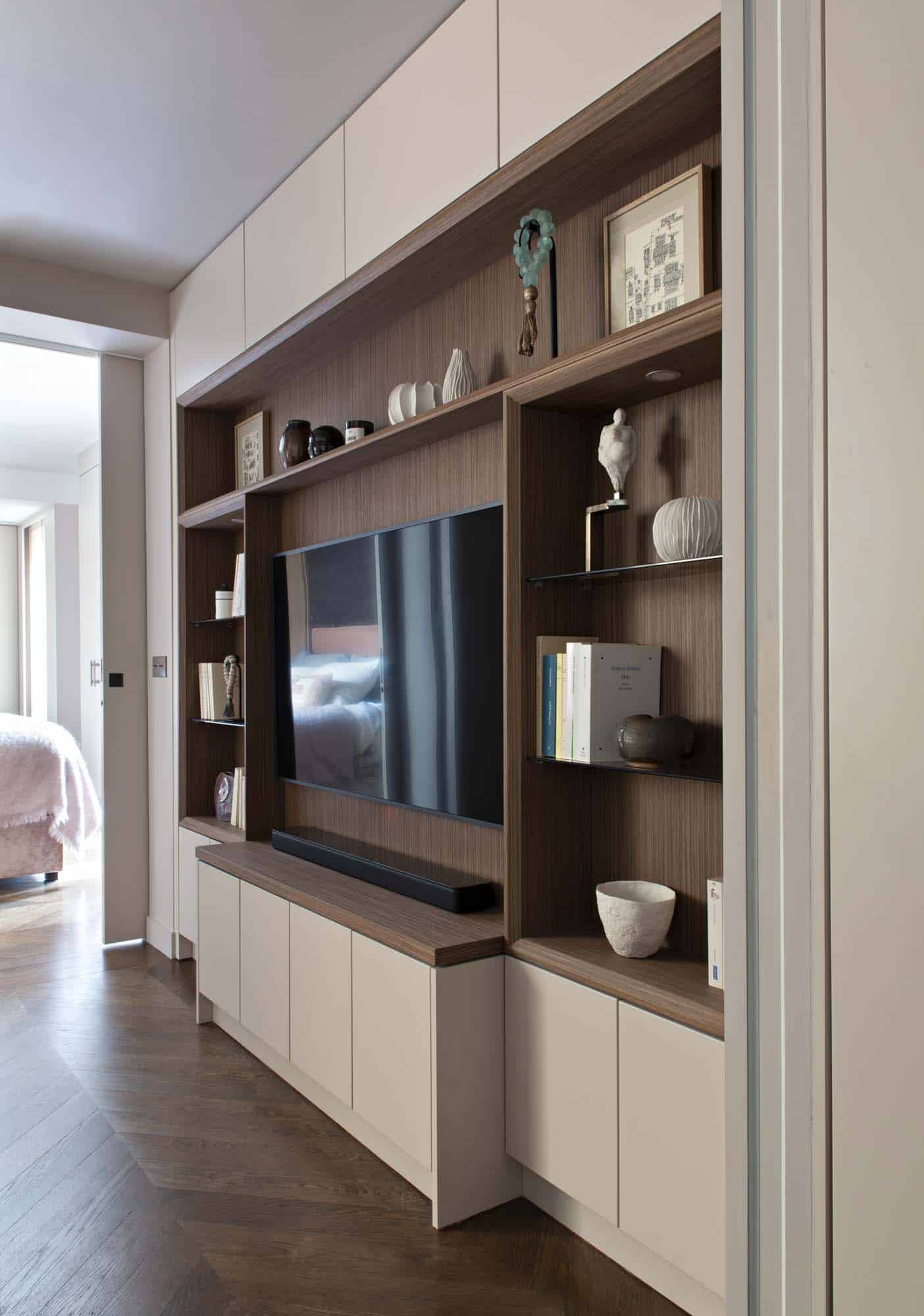 Meuble de menuiserie toute hauteur intégrant rangements et écran, ouvert sur l'enfilade vers la chambre