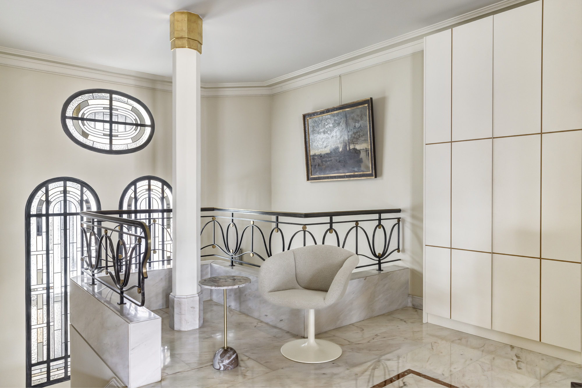 Palier haussmannien, fenêtres en arc et fauteuil design