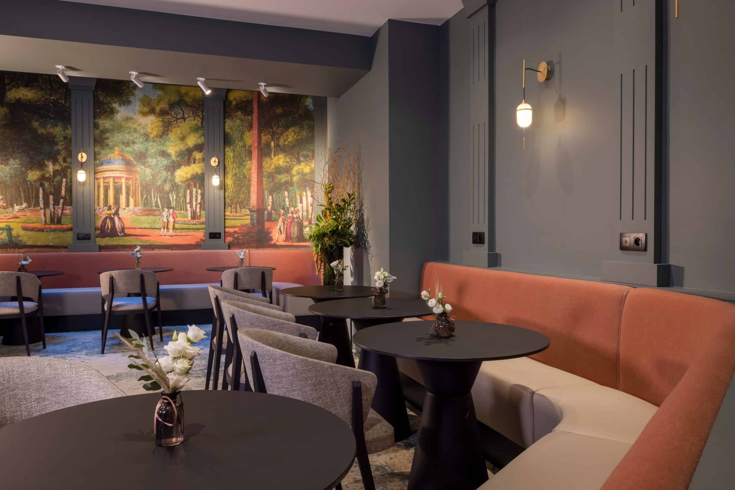 Salon du Grand Hôtel Levêque, banquette et tables devant le décor panoramique