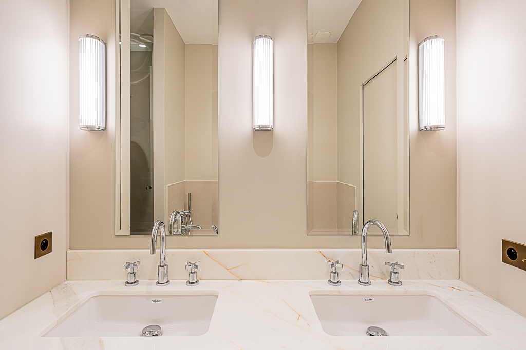 Salle de bain avec double vasque en marbre et appliques
