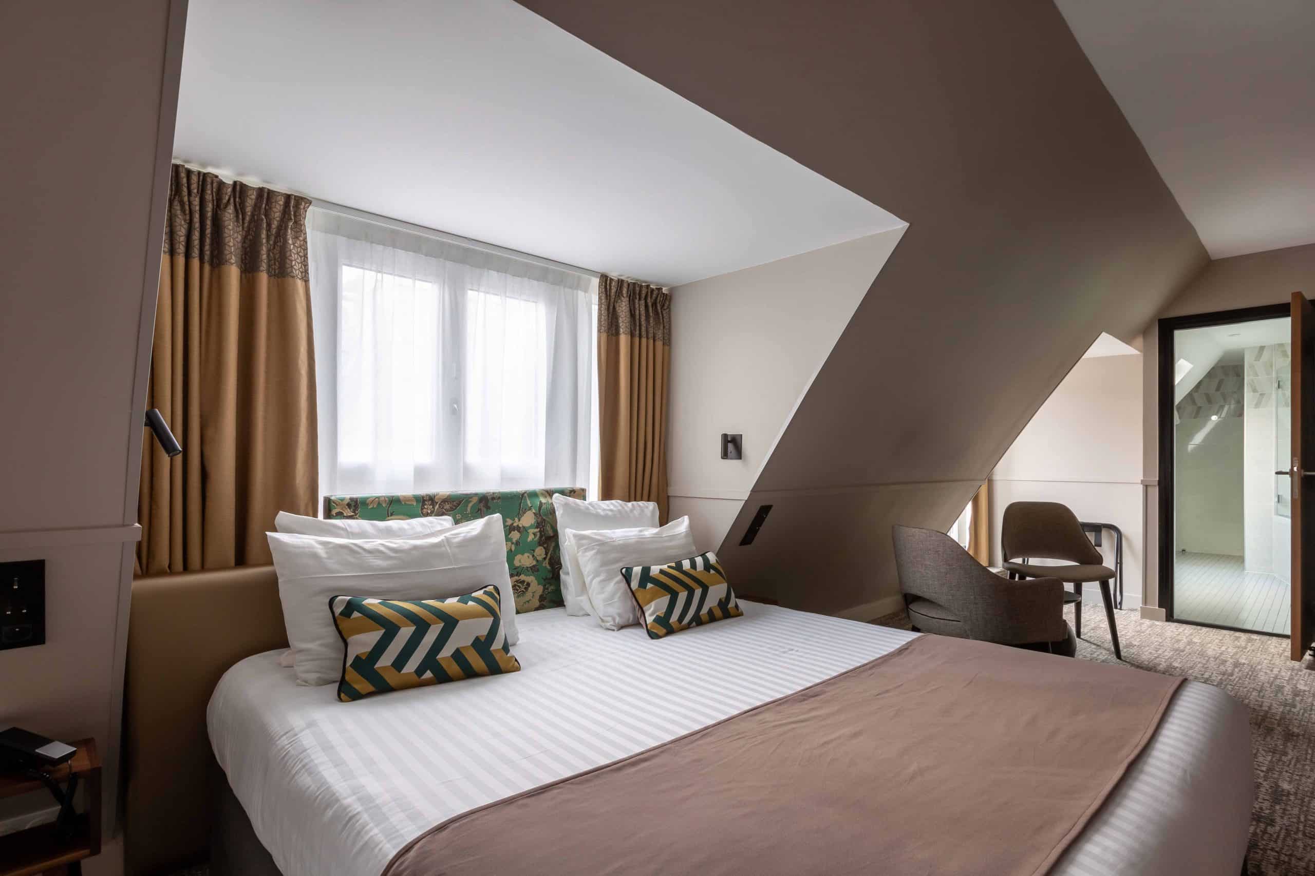 Chambre sous combles de l'Hôtel Daunou Opéra ouverte sur une fenêtre de toit